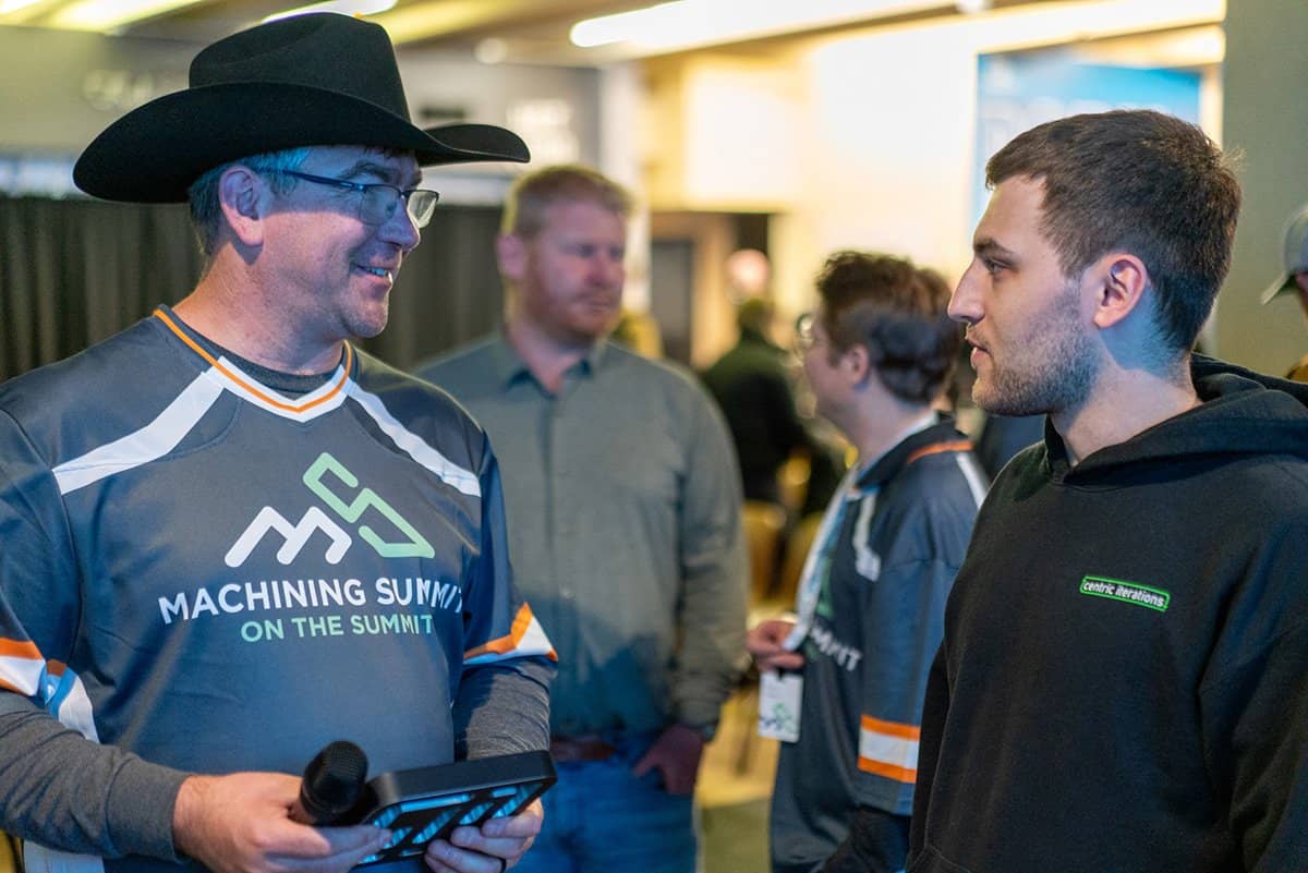 Two men deep in conversation at the Machining Summit
